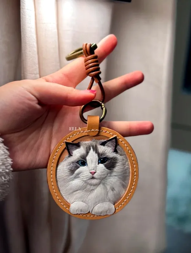 leather cat photo keychain held in hand